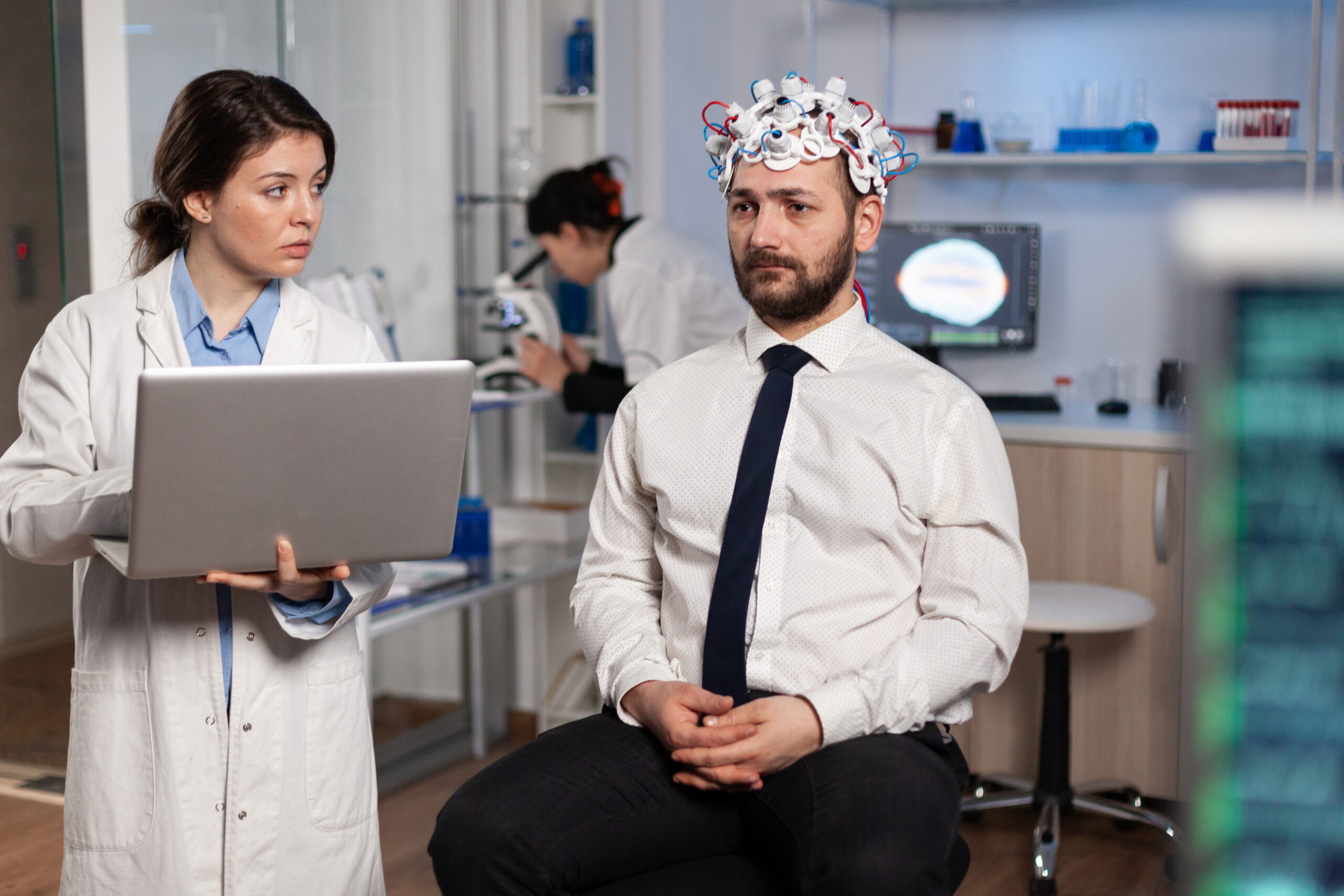 Doctor discussing a neurological evaluation with a patient wearing an EEG headset