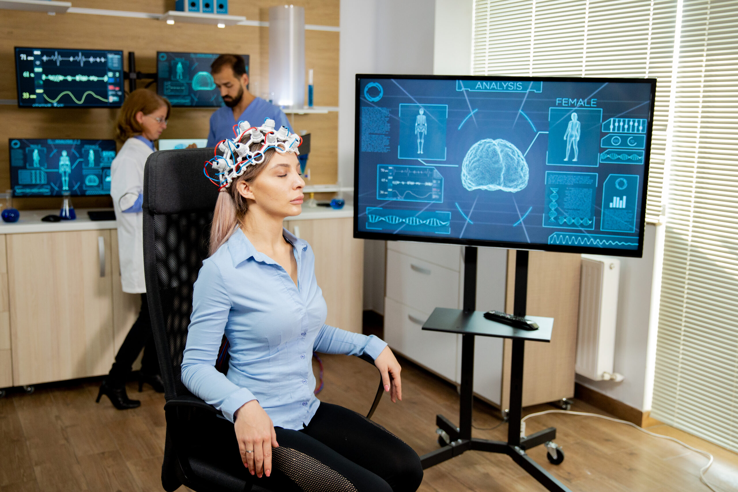 Patient during a neurofeedback brain mapping session with activity shown on screen